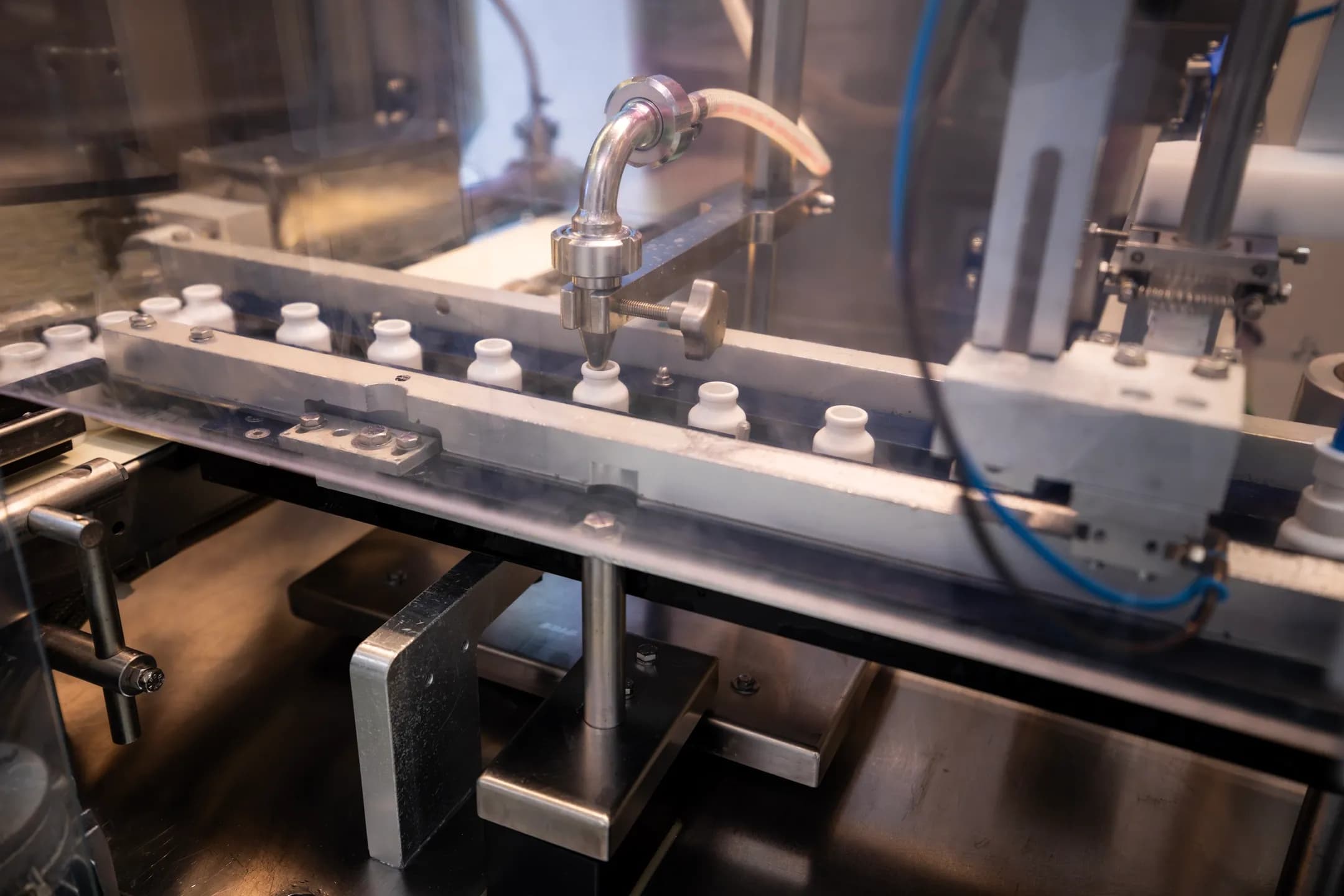 Automatische OPTOSOL-Abfüllanlage mit kleinen weißen Flaschen Detailaufnahme