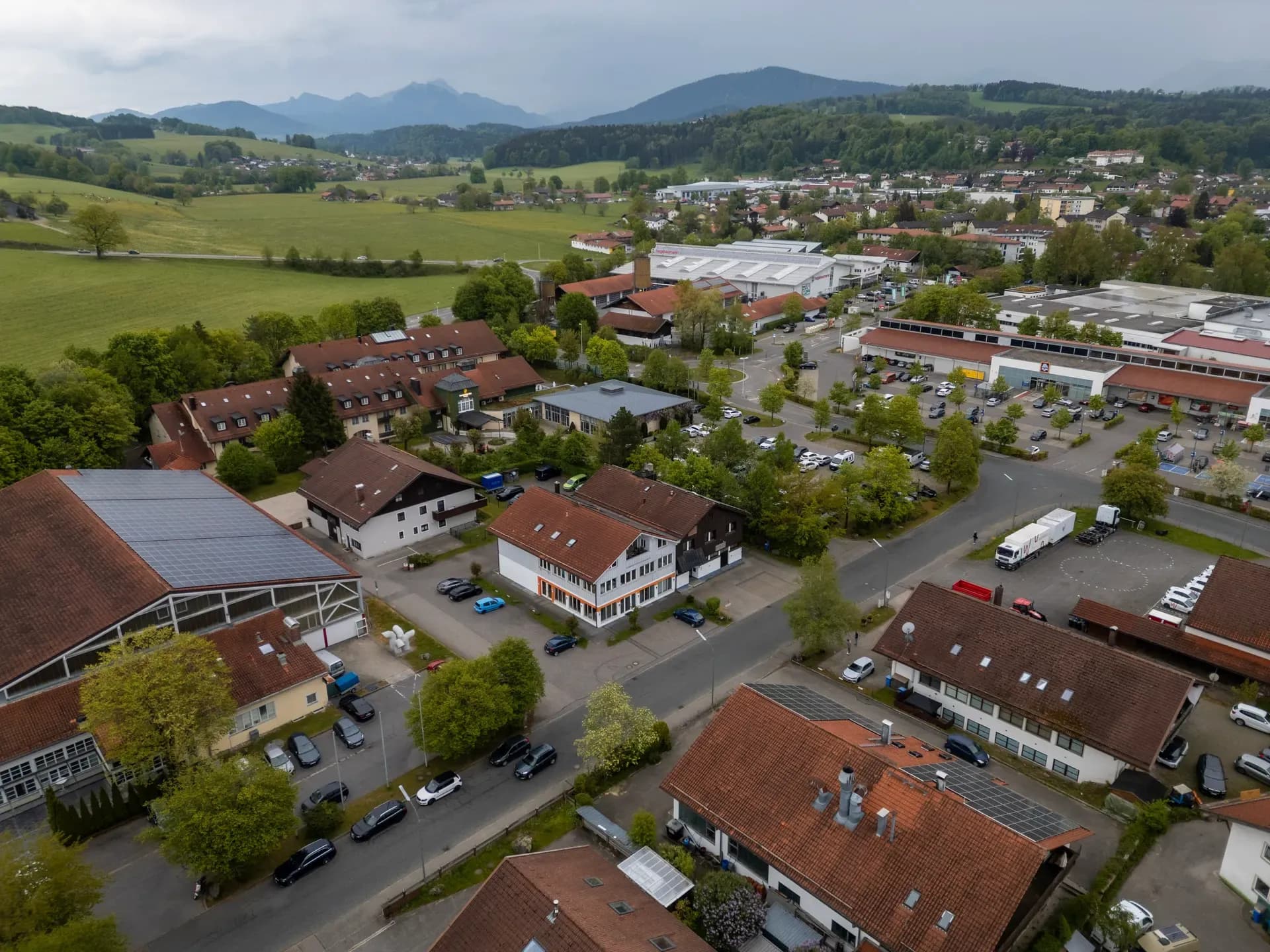 Drohnenaufnahme der OPTOSOL-Produktionsstätte in der Stadt Miesbach mit Berglandschaft